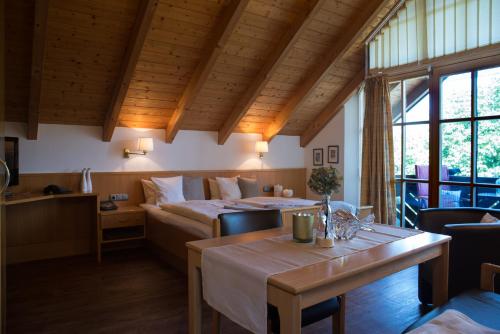 une chambre d'hôtel avec un lit, une table et des chaises dans l'établissement Appartementhaus Sibylle, à Bad Füssing