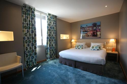 a hotel room with a bed and a window at Hotel De France in Valence