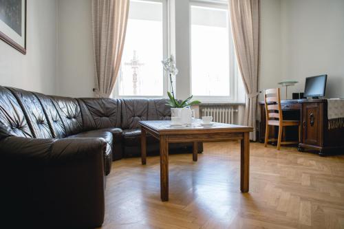 a living room with a leather couch and a table at Villa Kaunensis in Kaunas