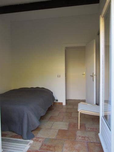 - une chambre avec un lit et un banc à côté d'une porte dans l'établissement Villa - Mas de la mer, à Théoule-sur-Mer