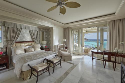 a bedroom with a large bed with a view of the ocean at Mandarin Oriental, Canouan in Canouan