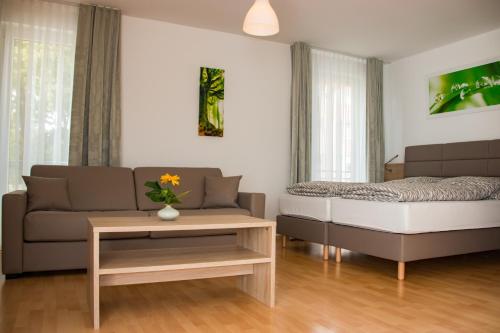 a living room with a couch and a bed and a table at Espelkamp Gästehaus in Espelkamp