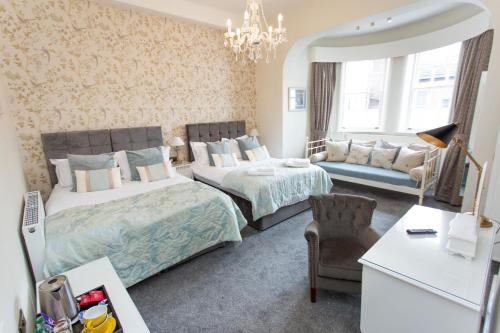 a bedroom with two beds and a couch at The Queens Hotel in Lytham St Annes