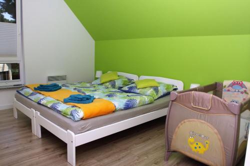 a bedroom with a bed and a green wall at Dom nad morzem z basenem in Międzywodzie