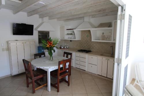 a kitchen with a table with a vase of flowers on it at Albachiara Hotel - Las Terrenas in Las Terrenas