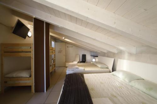 1 dormitorio con 2 camas y TV. en Nuovo Laghetto Del Frassino, en Peschiera del Garda