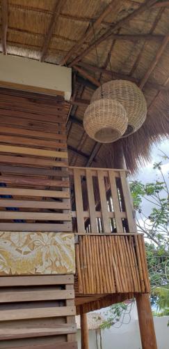 two baskets are hanging from the roof of a building at Poza Clara Sanctuary in Bacalar