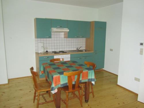 a kitchen with a table with chairs and blue cabinets at Schlossbrauerei Weinberg - Erste oö. Gasthausbrauerei in Kefermarkt
