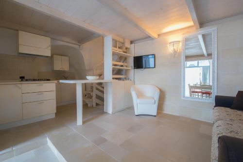 a kitchen with a table and a chair in a room at White Stone Flats & Studios in Ostuni