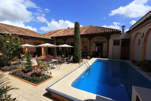 a courtyard with a swimming pool and a house at Hotel La Casa de Mamá in San Cristóbal de Las Casas