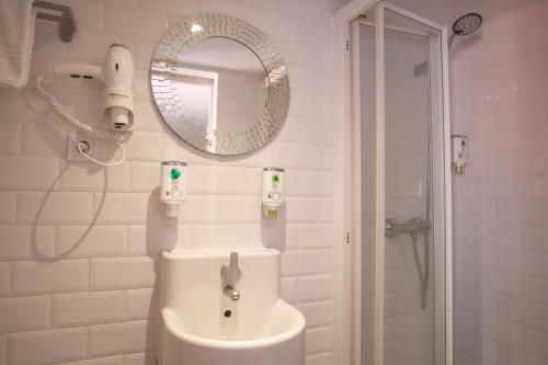 a bathroom with a sink and a mirror and a shower at Gran Central Suites in Madrid