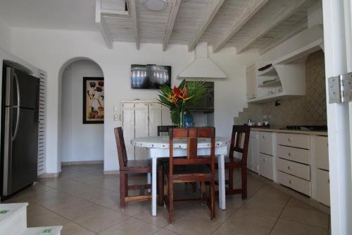 a kitchen with a white table and chairs and a kitchen with white cabinets at Albachiara Hotel - Las Terrenas in Las Terrenas