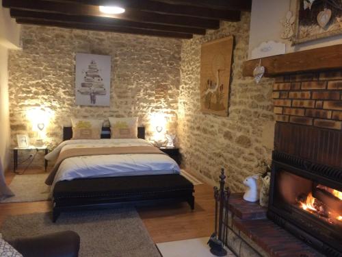 a bedroom with a bed and a fireplace at Maison familiale Centre France in Meunet-sur-Vatan