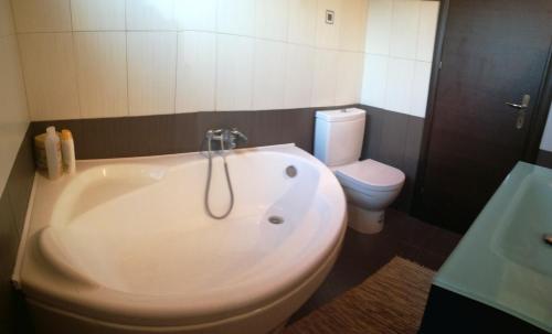 a white tub in a bathroom with a toilet at AgroPhilia in Kourkouloí