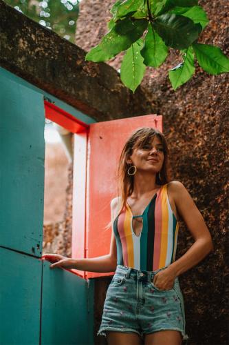 a woman in a striped bikini top standing in front of a door at Cliff Stories in Varkala
