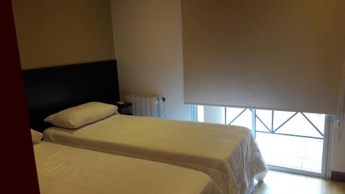 2 camas en una habitación pequeña con ventana en Los Perales en San Salvador de Jujuy