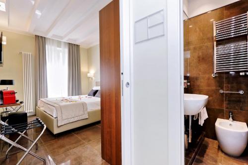 una camera da letto con un letto e un bagno con un lavandino di Piazza Venezia Grand Suite a Roma