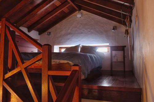 GuarazocaにあるCasa Rural El Teniqueのベッドルーム1室(ベッド1台付)、木製の階段