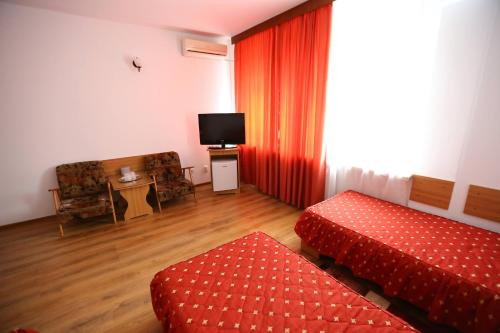 a hotel room with two beds and a television at Hotel Moldova in Bîrlad