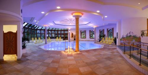 a large room with a swimming pool in a house at Ferienhotel Sonnenhof in Zell am Ziller