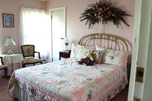 a bedroom with a bed with a flower arrangement on the wall at Belle Aire Mansion Guest House in Galena