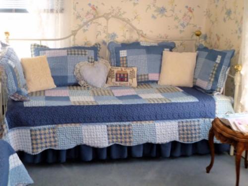 a bedroom with a blue and white bed with pillows at Belle Aire Mansion Guest House in Galena