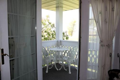 a porch with a table and a glass door at Belle Aire Mansion Guest House in Galena