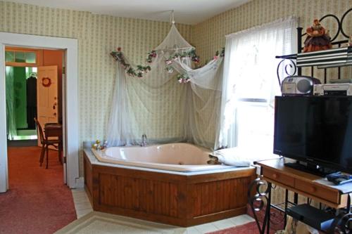 a large bath tub in a living room with a tv at Belle Aire Mansion Guest House in Galena
