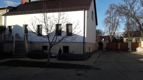 a white house with a tree in front of it at Ferienwohnung Zossen in Zossen