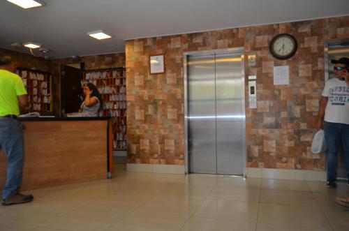 a woman standing at a counter in a library with a clock at Stgo centro, Departamentos Amoblados Paz in Santiago