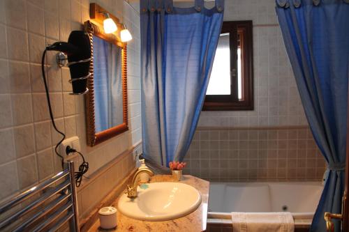 a bathroom with a sink and a tub with a window at Suite Castillejo in Capileira