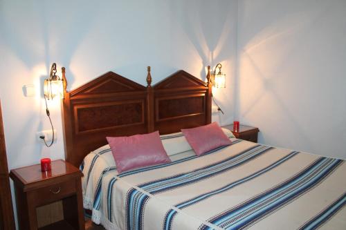 a bedroom with a bed with two pink pillows at Suite Castillejo in Capileira