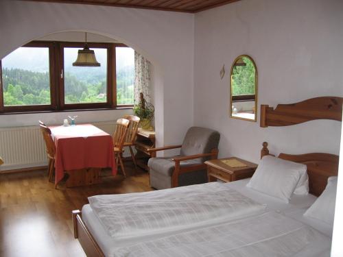 sypialnia z łóżkiem, stołem i krzesłami w obiekcie Backer-Ferdl Panzio w mieście Hinterstoder
