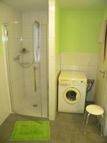 a bathroom with a shower and a washing machine at Ferienwohnung Kühl in BooÃŸen