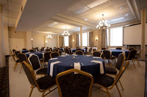 a conference room with tables and chairs and a screen at Prince Arthur Waterfront Hotel & Suites in Thunder Bay