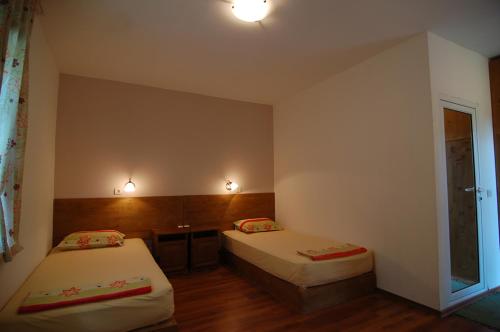 a bedroom with two beds and a desk and a window at Sinia Vir Eco Residence in Medven