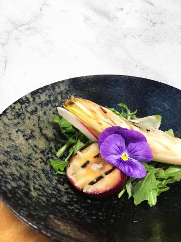 a plate of food with a purple flower on it at YO1 Longevity & Health Resorts, Catskills in Monticello
