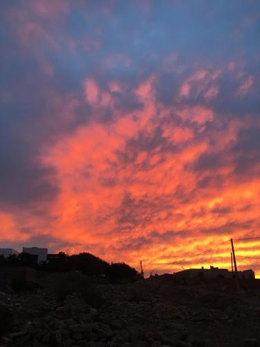 a sunset in the sky with red clouds at Auberge De La Plage in Sidi Kaouki