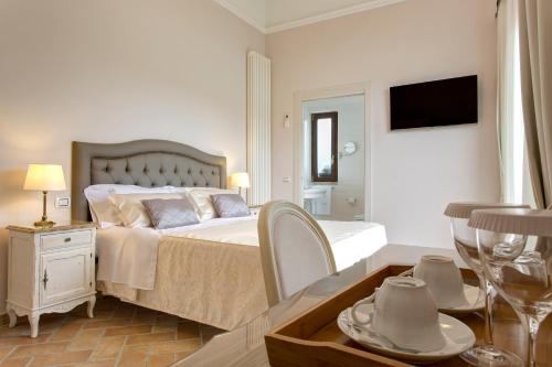 a bedroom with a bed and a table with chairs at Relais Borgo Gentile in Tarano