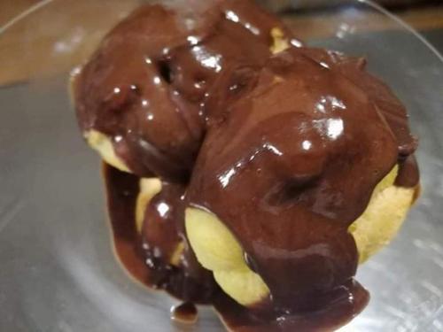 two chocolate covered donuts sitting on a plate at Relais Borgo Gentile in Tarano