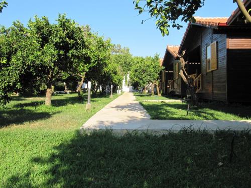 a sidewalk next to a house and trees at Baris Pension & Bungalows in Cıralı