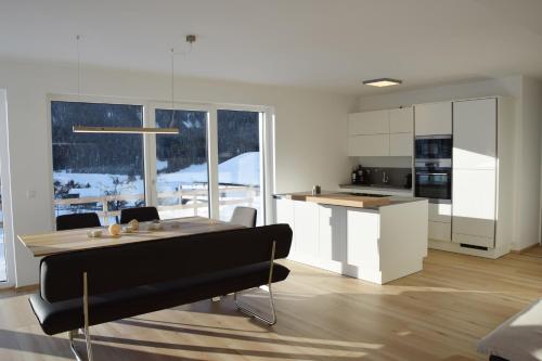 uma cozinha e sala de jantar com mesa e cadeiras em Ferienhaus Lurger em Strassen
