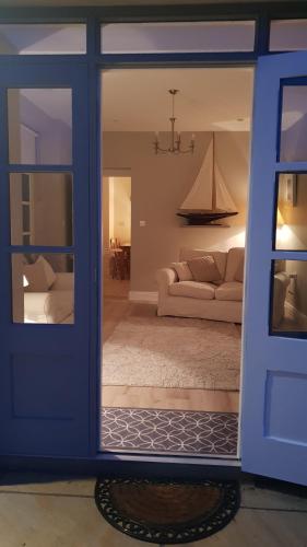 a living room with a blue door and a couch at The Coach House Douglas in Cork