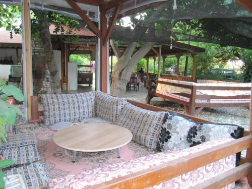 a couch sitting on a patio with a table at Baris Pension & Bungalows in Cıralı