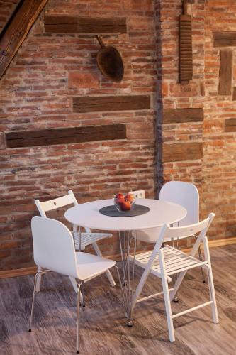 a table and chairs in a room with a brick wall at 7 Apartments in Lviv