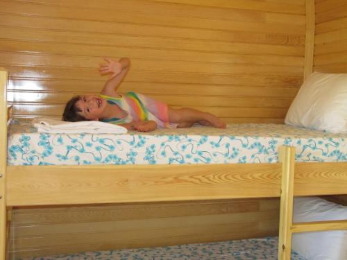 a young girl laying on a bunk bed at Baris Pension & Bungalows in Cıralı