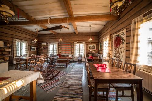 a living room with wooden walls and tables and chairs at Villa Seppälä in Ranua