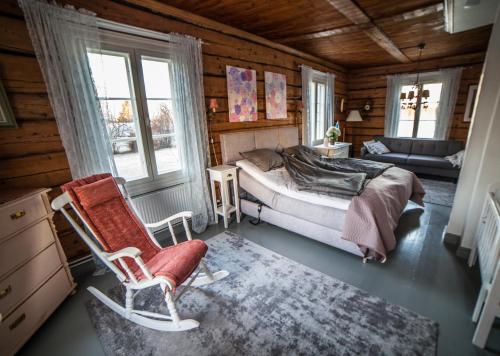 a bedroom with a bed and a chair in a room at Villa Seppälä in Ranua