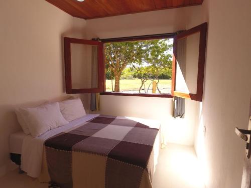 a small bedroom with a bed and a window at Condomínio Mar Aberto in Praia do Espelho