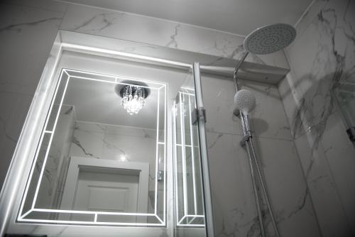 łazienka z lustrem i żyrandolem w obiekcie Glamour Apartments w mieście Piła